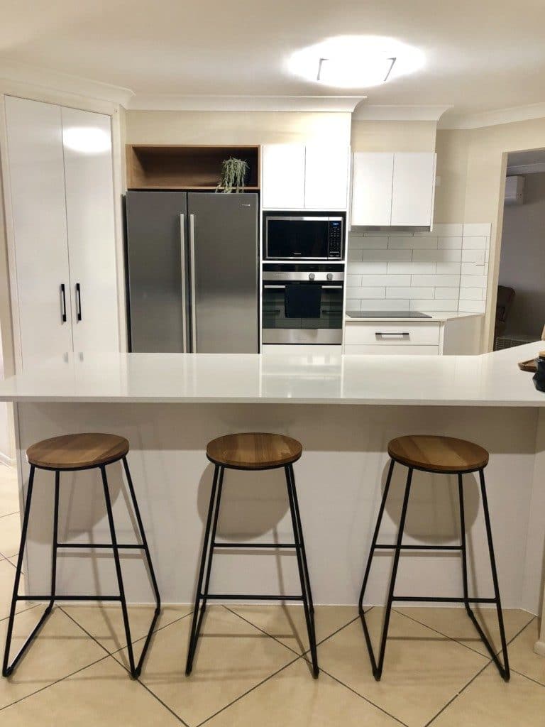 White Kitchen, tiles, stools, lighting, laminate, black handles, overhead, island bench