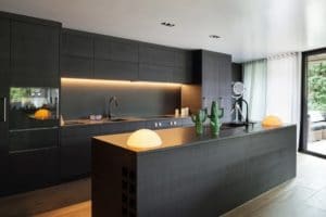 Modern kitchen with black furniture and wooden floor